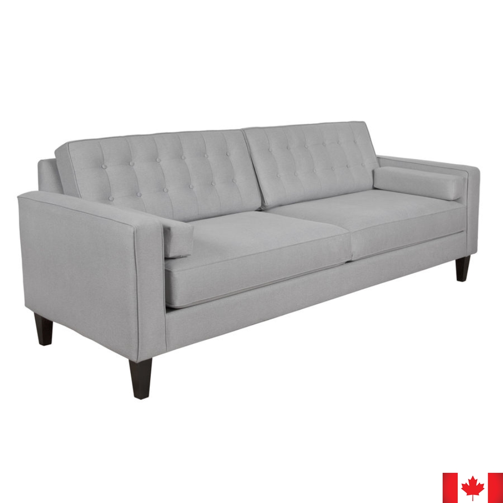 Light grey sofa with boxy shape, and 2 rows of button tufting on loose back cushions.